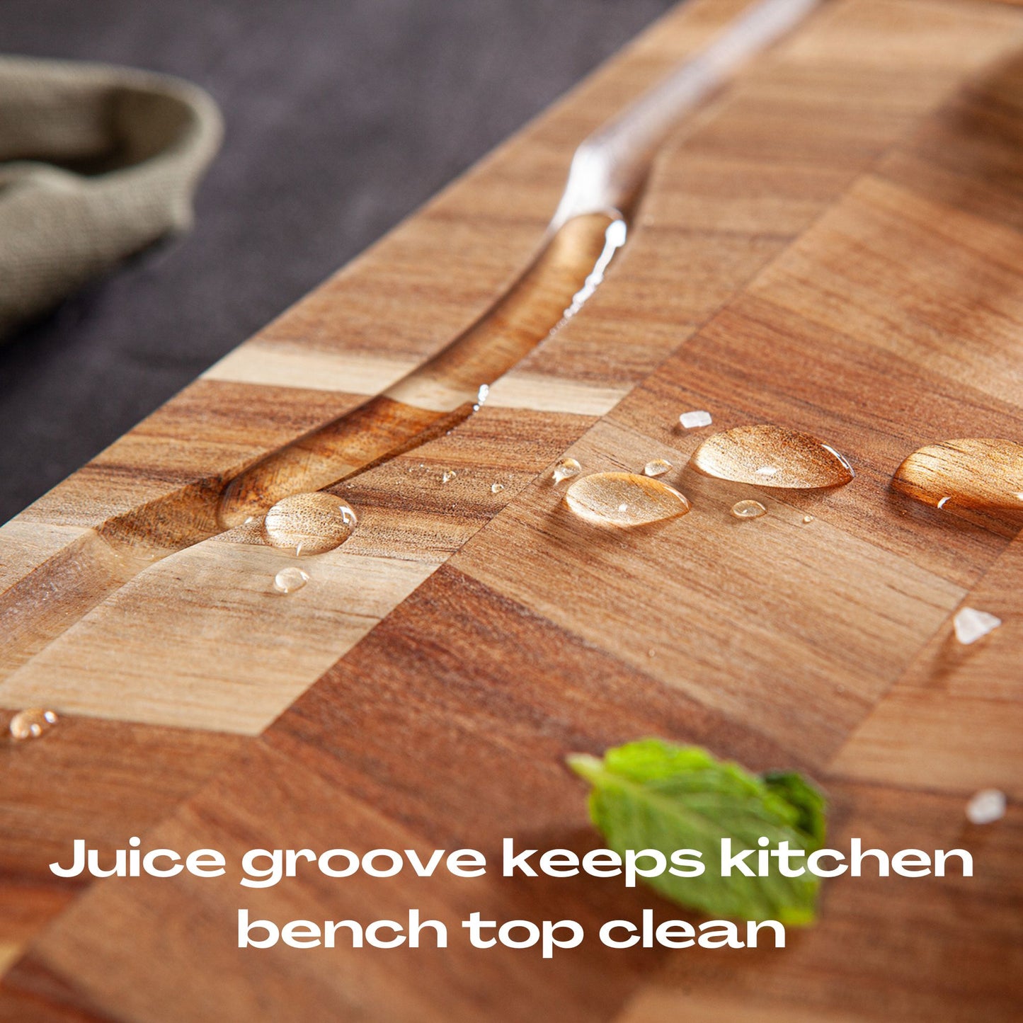Acacia wood chopping board showing juice groove prevents liquid from spilling onto kitchen bench.